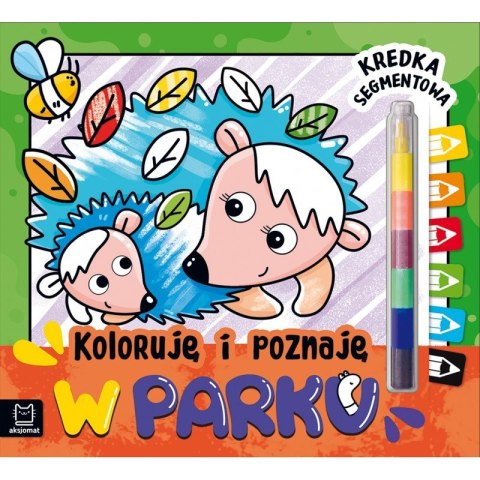 Okładka książeczki „Koloruję i poznaję – W parku” z jeżami, kolorowymi liśćmi i dołączoną kredką segmentową.
