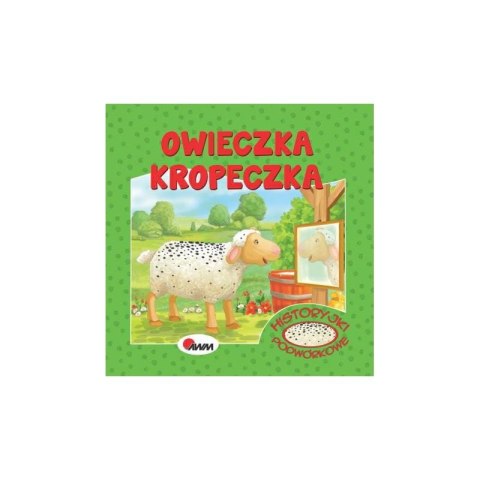 Okładka książeczki „Owieczka Kropeczka” z ilustracją owieczki w kropki patrzącej w lustro na tle łąki