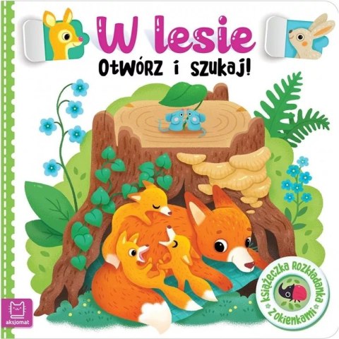Książka dla dzieci „W Lesie – Otwórz i Szukaj!” z ilustracją lisów ukrytych przy pniu drzewa.
